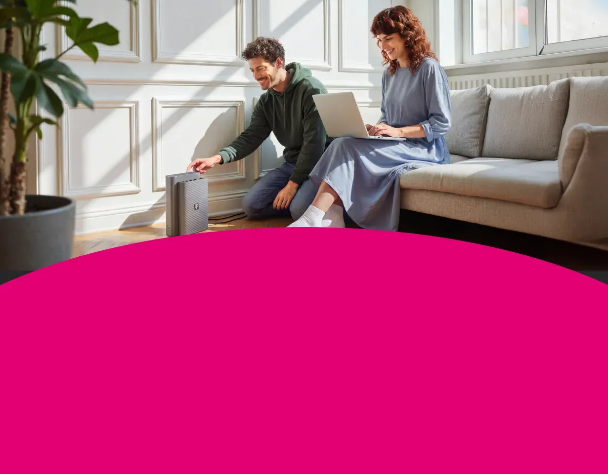 Zwei Personen freuen sich über ihren Glasfaser-Anschluss und Router